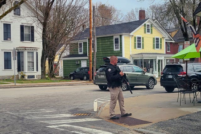 A police officer stands on the corner of Portland Street and Main Street in Yarmouth, Maine