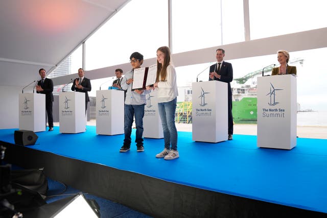 Two children hold up the Ostend Declaration after signatures by heads of state during a media conference at the North Sea Summit in Ostend, Belgium