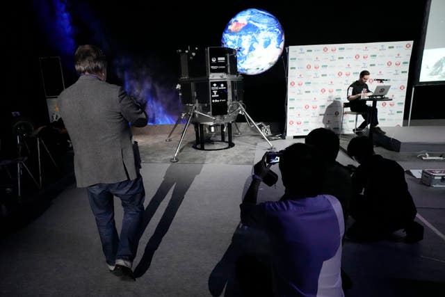 Journalist film the models of the lander and the lunar rover of Hakuto-R private lunar exploration programme prior to the livestream of the lunar landing event