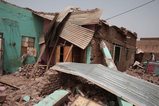 A man walks by a damaged house in Khartoum