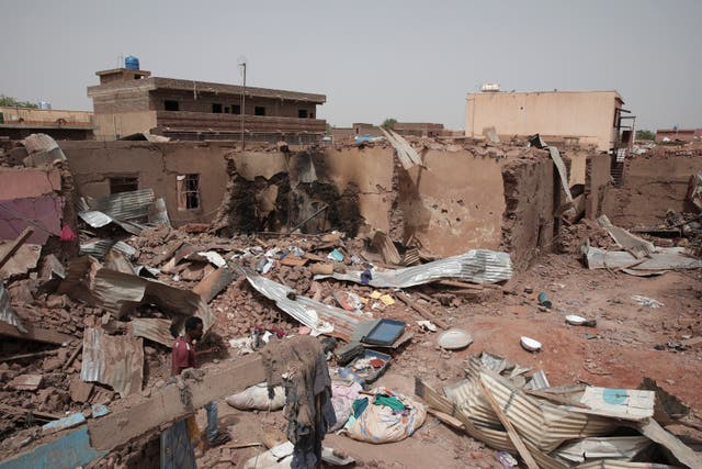 A man walks by a house hit in recent fighting in Khartoum 