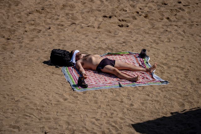 A man sunbathes on the beach in Barcelona