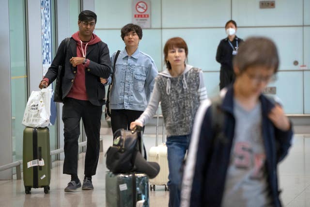 Travellers walk through the international flight arrivals area at Beijing Capital International Airport 
