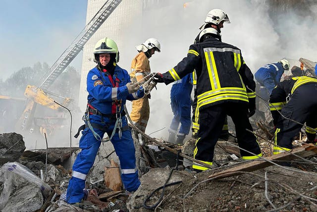Firefighters work at an apartment building destroyed by a Russian attack in the town of Uman