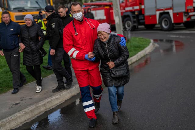 A woman cries next to the residential building hit in Uman