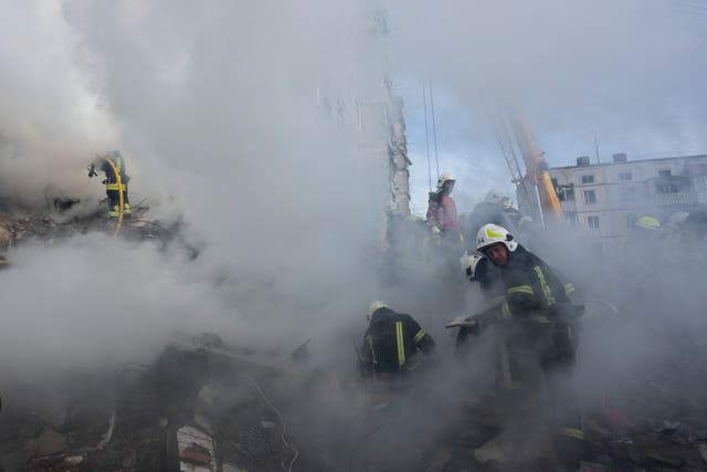 Firefighters work to extinguish a fire after a Russian attack at a residential building in Uman