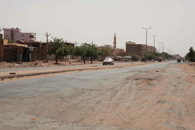 A vehicle crosses an empty street in Khartoum, Sudan
