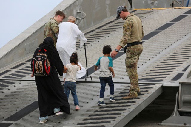 US soldiers escort American nationals to a US Navy ship in Port Sudan