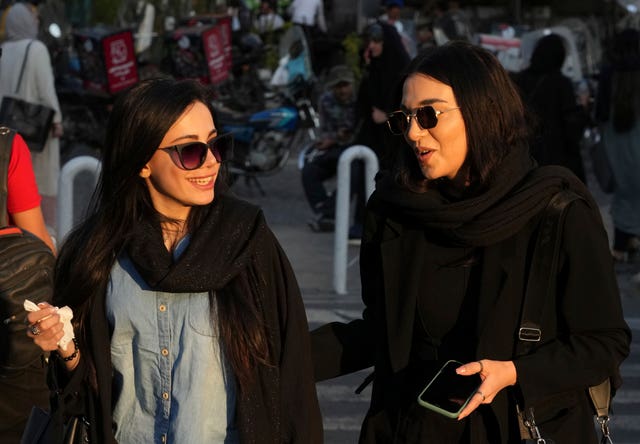 Women without headscarves walk in Tehran 