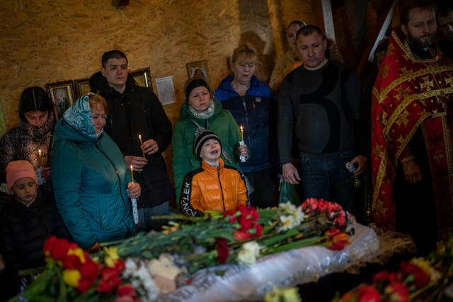 Mykhayl Shulha, centre, cries next to the coffin of his sister Sofia Shulha during a funeral prayer in Uman, central Ukraine 
