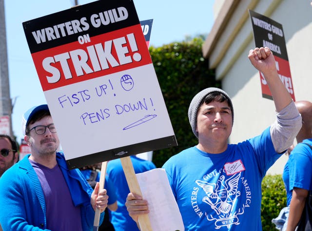 Writers Guild of America West member Victor Duenas pickets with others at an entrance to Paramount Pictures in Los Angeles