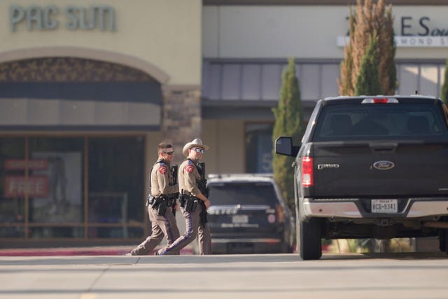 Law enforcement officers patrol a shopping center after a shooting in Allen, Dallas, Texas