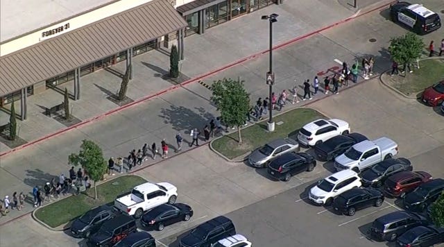 In this frame grab from video provided by WFAA, people are evacuated from Allen Premium Outlets, Saturday, May 6, 2023, in Allen, Texas.  Law enforcement respondents to reports of a shooting at the outlet mall, in the Dallas area