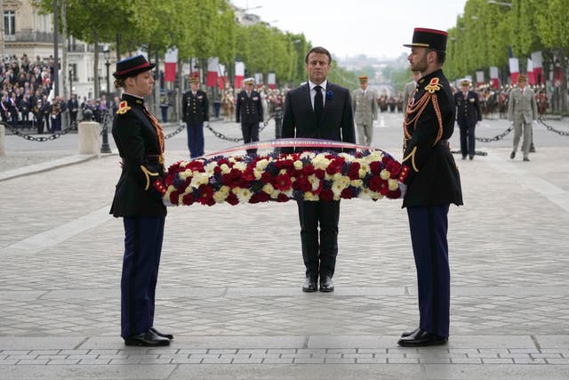 French President Emmanuel Macron lays a wreath of flowers at the Unkown Soldier tomb under the Arc de de Triomphe during ceremonies marking Victory Day in Paris 