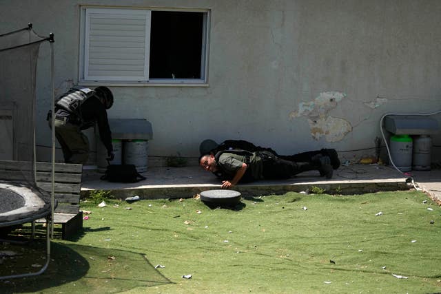 Israeli security forces take cover during an air raid siren 
