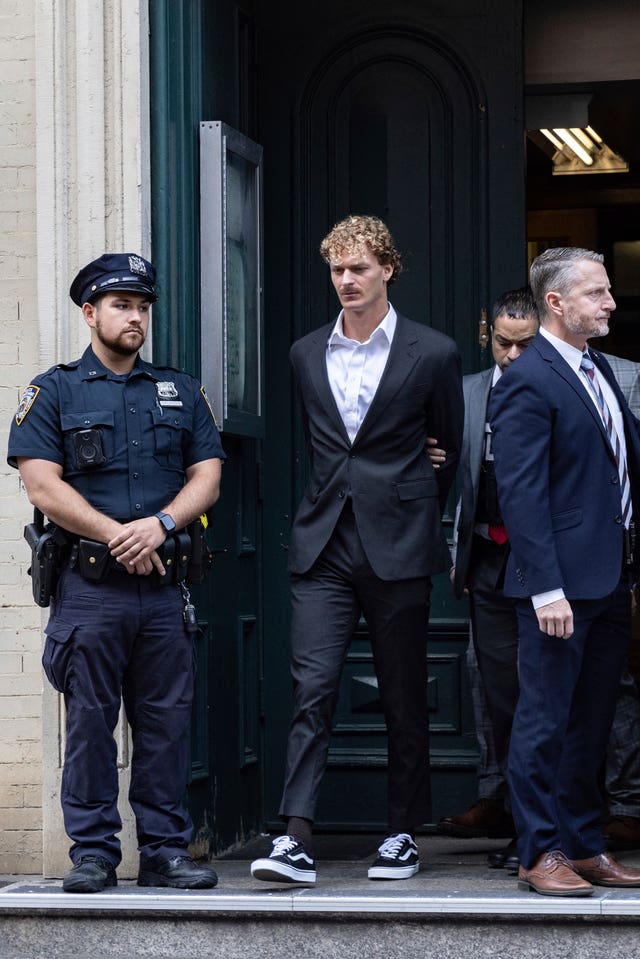 Daniel Penny, centre, is walked by New York Police Department detectives out of the 5th Precinct in New York