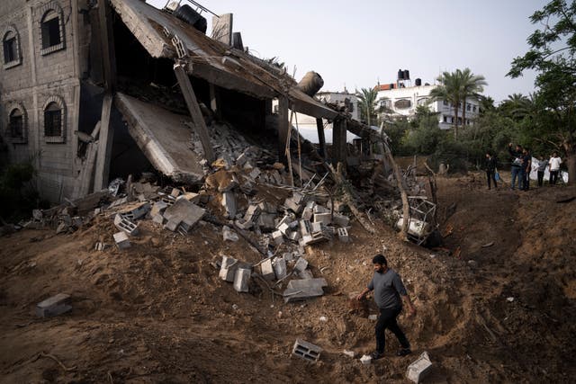 Palestinians inspect the rubble of a house after it was struck by an Israeli air strike in Deir al-Balah, central Gaza Strip 