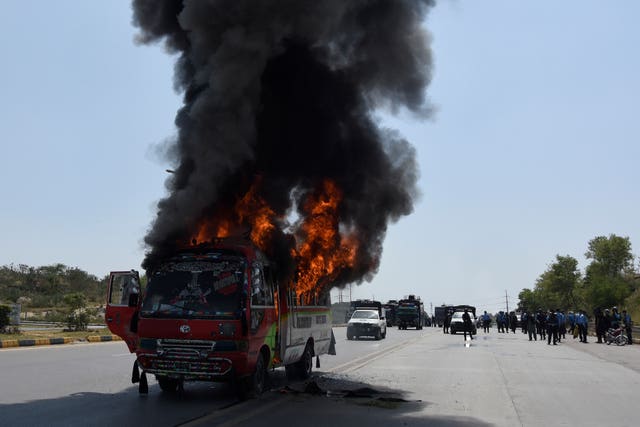 Smoke rises from a burning bus during clashes with the supporters of Pakistan’s former prime minister Imran Khan and police, in Islamabad, Pakistan