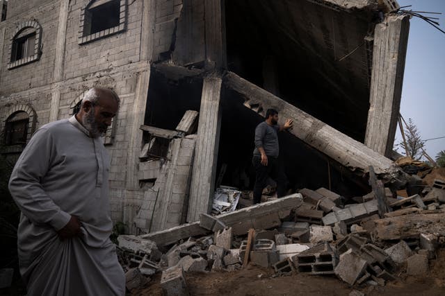 Palestinians inspect the rubble of a house after it was struck by an Israeli air strike in Deir al-Balah, central Gaza Strip