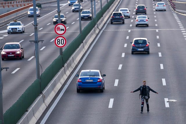 A man attempts to block a motorway during a rally against violence in Belgrade, Serbia