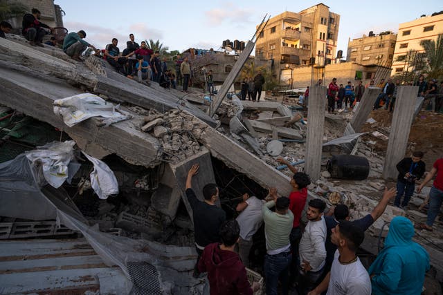 Palestinians inspect the rubble of Islamic Jihad member Zeyad Selmi’s house after it was hit by an Israeli air strike in Gaza City