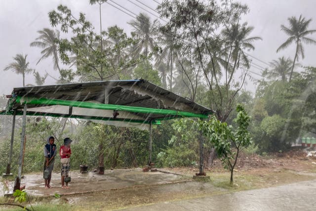 Children stand under a roadside shelter before Cyclone Mocha makes landfall in Rakhine State, Myanmar