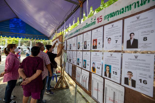 Voters check candidates' information at a polling station in Bangkok 