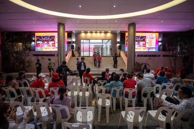 Pheu Thai supporters watch a real-time update of vote counting through a screen at party headquarters in Bangkok 