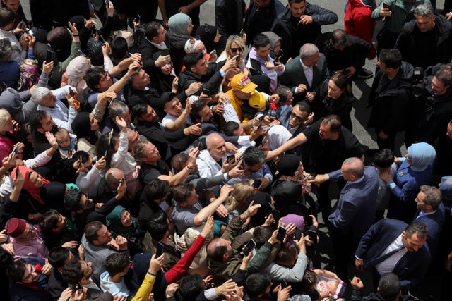 Turkish president Recep Tayyip Erdogan, centre right, and his wife Emine, right, meet supporters outside a polling station in Istanbul 