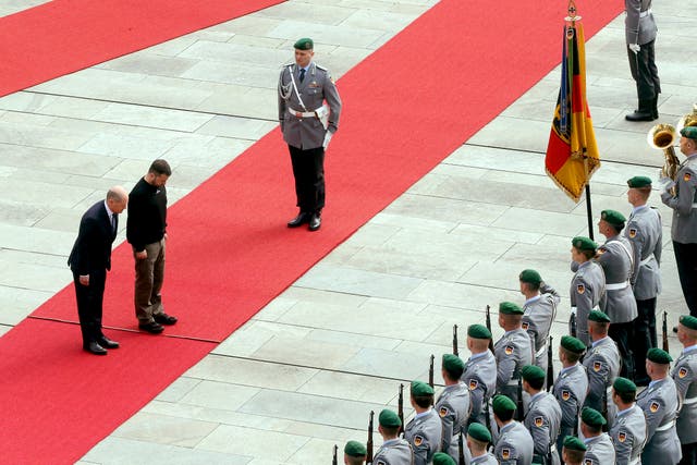 Ukrainian president Volodymyr Zelensky, centre, and German chancellor Olaf Scholz review the honour guard at the Federal Chancellery in Berlin 