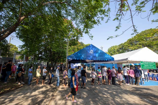 Voters wait in line outside a polling station in Bangkok 