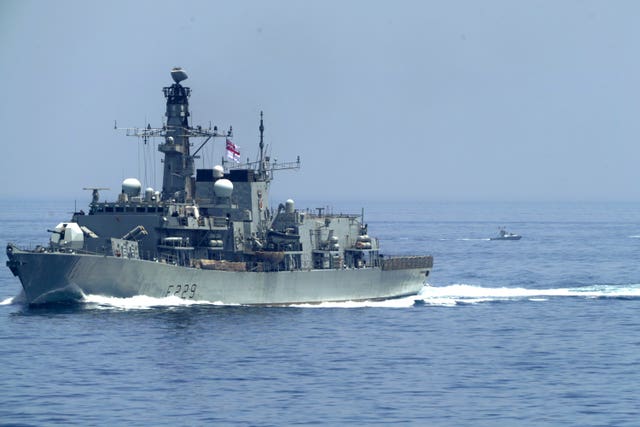 The British frigate HMS Lancaster sails as Iranian Revolutionary Guard vessels follow behind it in the Strait of Hormuz