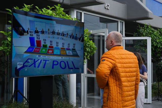 Supporters of Greece’s Prime Minister and leader of New Democracy watch the exit poll at the headquarters of his party in Athens, Greece