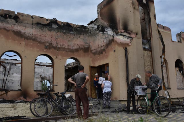 Local residents receive humanitarian aid from a volunteers in front of Evangelical Christian Baptists prayer house which was destroyed yesterday by a Russian attack in Orihiv, Ukraine 