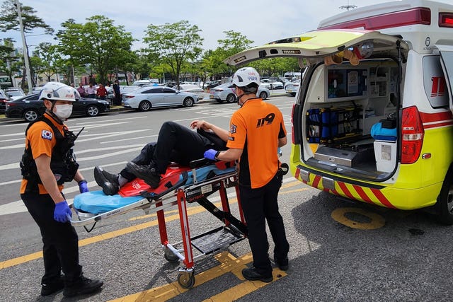 Rescue workers move a passenger on a stretcher to an ambulance at Daegu International Airport in Daegu