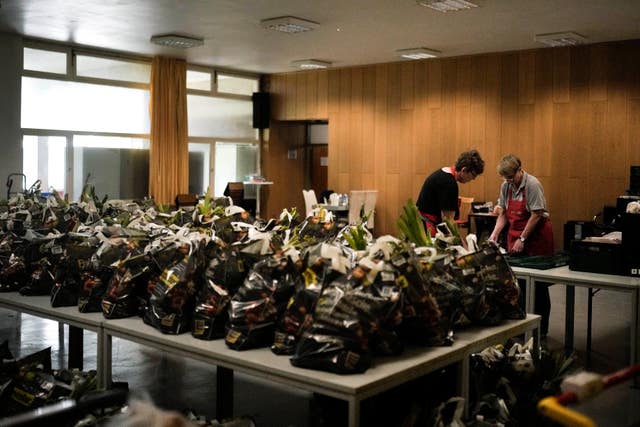 Women prepare bags with groceries for delivery at a food distribution centre at the Catholic St William Church in Berlin, Germany
