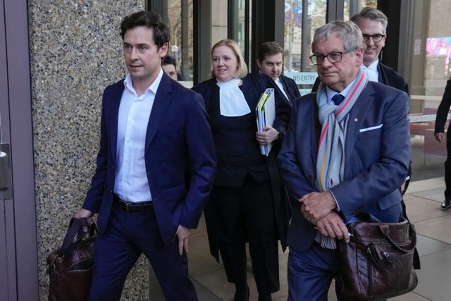 Australian journalists Nick McKenzie, left, and Chris Masters, right, walk with their legal team