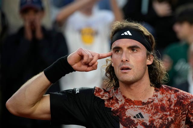 Stefanos Tsitsipas points to his head after reaching the quarter-finals