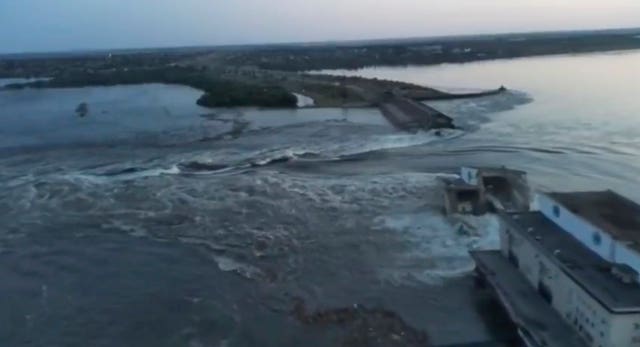 Water runs through a breakthrough in the Kakhovka dam in Kakhovka, Ukraine 