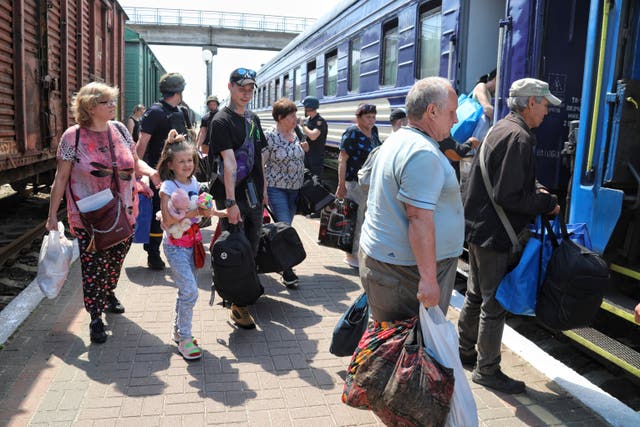 People board an evacuation train at a railway station in Kherson, Ukraine