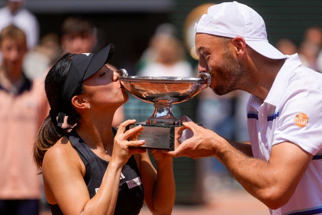 Miyu Kato, left, and Tim Puetz kiss the trophy 