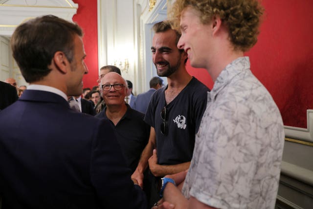French President Emmanuel Macron meets Henri, second right, the 24-year-old ‘backpack hero’ 