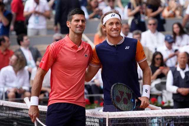 Novak Djokovic (left) and Casper Ruud pose at the net