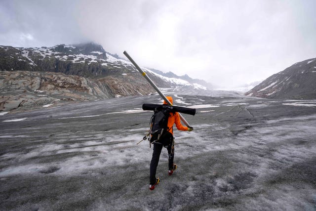 A glaciologist walks to the Rhone Glacier near Goms 