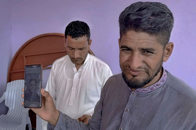 Raja Sakundar, right, holds a picture of his missing nephew on his phone