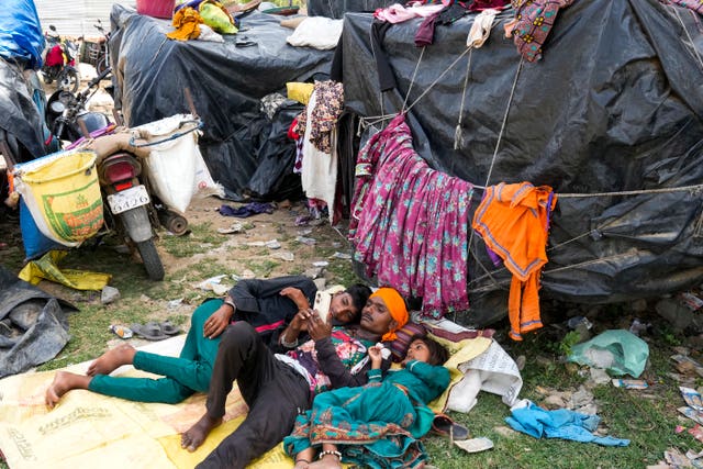 A nomadic family rest in shade outside their tent in Lalitpur district in northern Uttar Pradesh state 