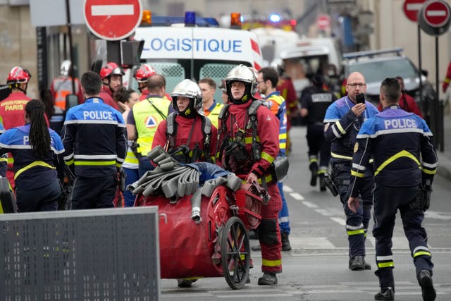 Police officers and rescue workers work at the scene  in Paris