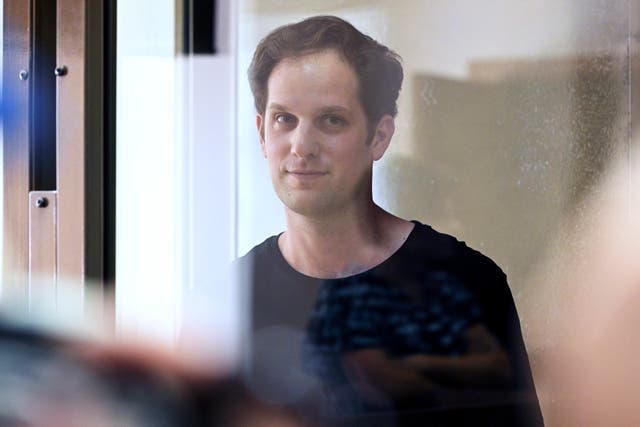 Wall Street Journal reporter Evan Gershkovich stands in a glass cage in a courtroom at the Moscow City Court in Russia