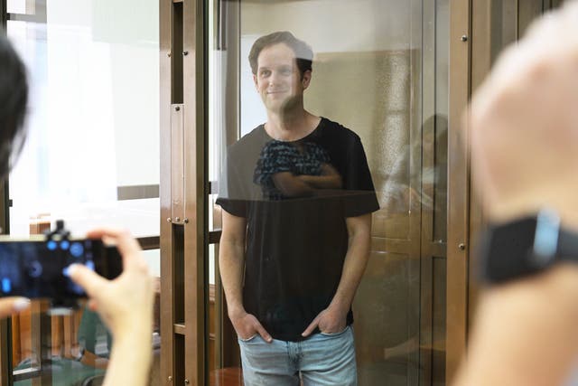 Wall Street Journal reporter Evan Gershkovich stands in a glass cage in a courtroom at the Moscow City Court