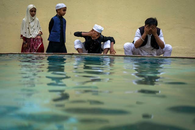 A Muslim family performs ablution before prayers during Eid in Kathmandu, Nepal